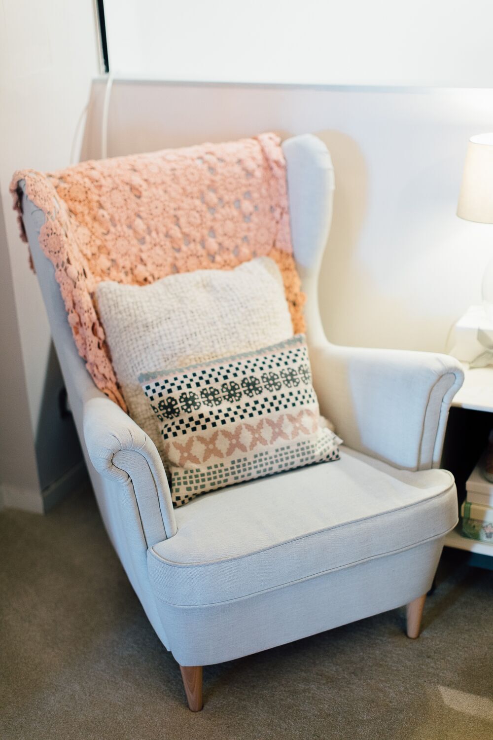 Grey nursing chair with pastel pink accessories