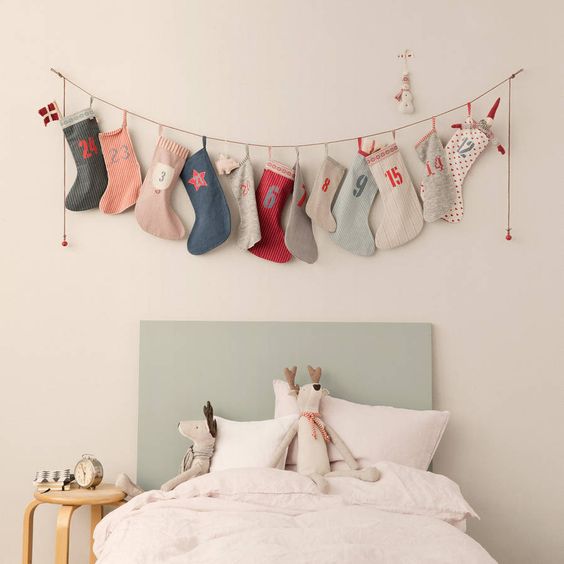 Homemade Advent Calendars For Kids. Fabric stocking advent garland hung from childrens bed.
