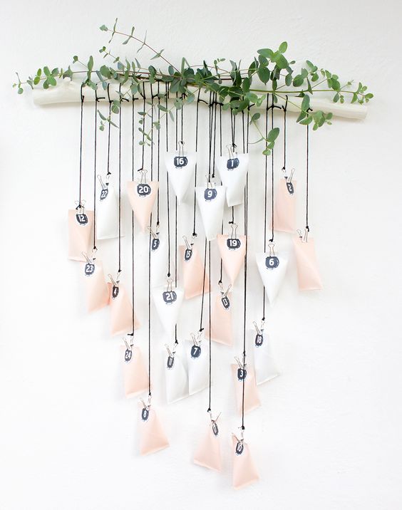Homemade Advent Calendars For Kids. Hanging advent calendar in white and blush hung from branch.