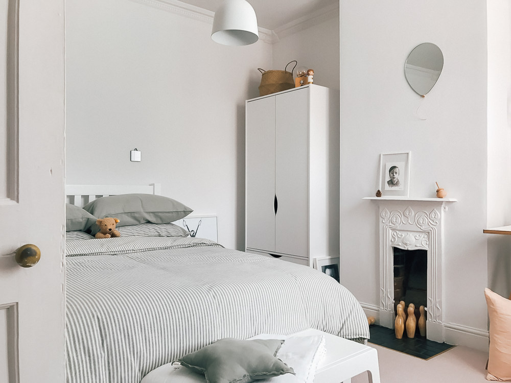 A modern neutral millennial pink bedroom for children with handmade furniture, personalised artwork and statement lighting